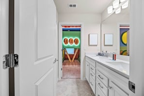 A bathroom with a white vanity, a mirror, and a sink. - 10BR house sleeps 24 with pool and game room (Clermont)