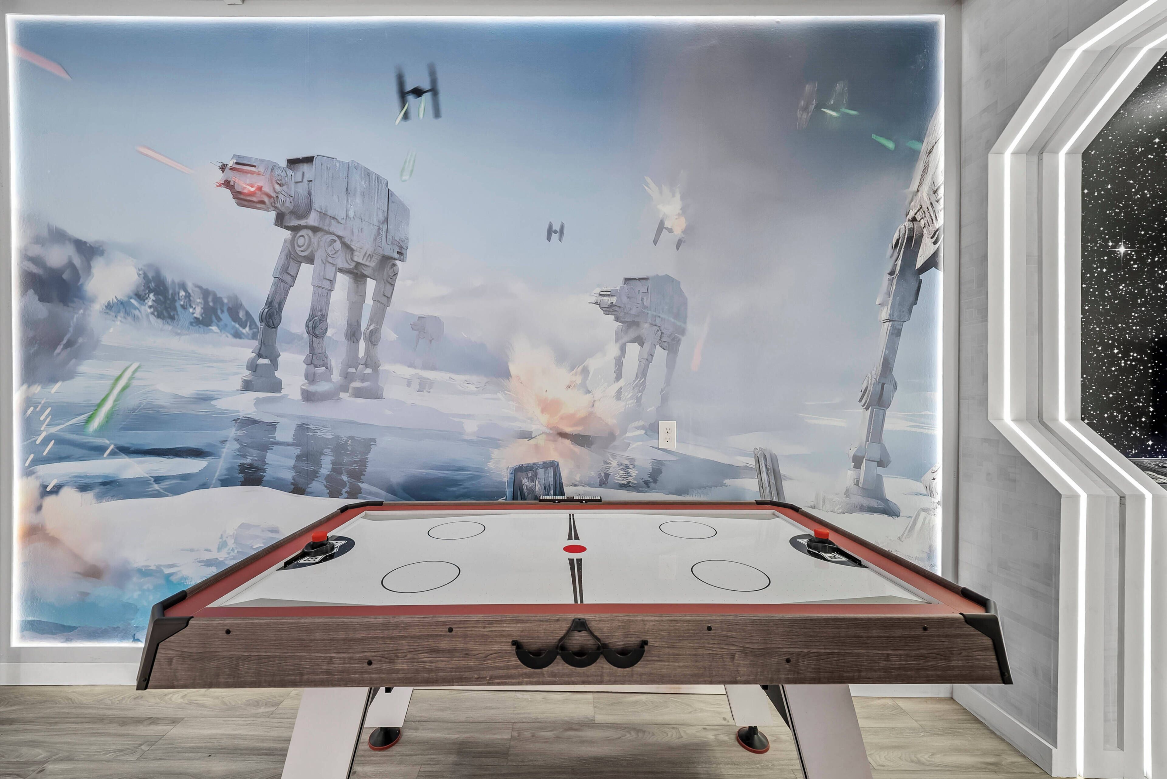 A pool table with a Star Wars-themed mural in the background.
