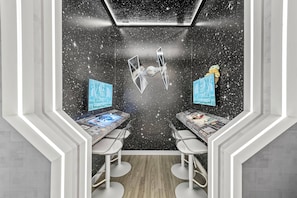 A room with a starry wall, two desks with monitors, and a ceiling light. - 10BR house sleeps 24 with pool and game room (Clermont)