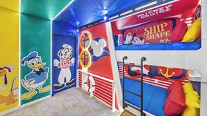 A children's play area with colorful walls, cartoon character decorations, and bunk beds. - 10BR house at Windsor Cay Resort (Clermont)
