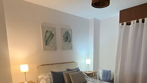 A bedroom with a bed, two bedside tables, a nightstand, a wooden chair, a ceiling fan, and a window with curtains. - Like at Home, Apartment in the center of Cordoba Capital, close to everything! (Córdoba)