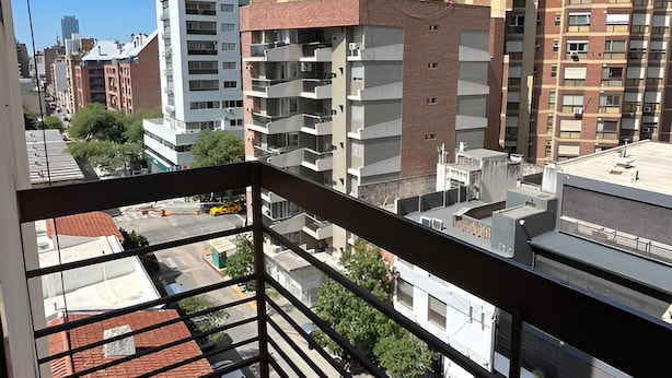 A balcony with a view of multi-story buildings, a clear sky, and a tiled floor. - Like at Home, Apartment in the center of Cordoba Capital, close to everything! (Córdoba)