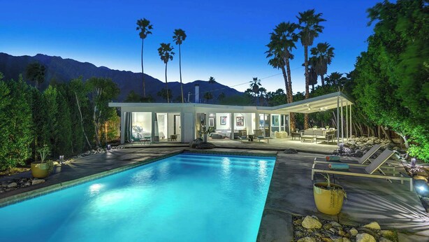 Ein modernes Haus mit Swimmingpool, Terrasse und Bergblick.
