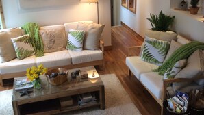 Un salon confortable avec un canapé, une table basse et une lampe.