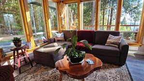 A cozy living room with a sofa, a coffee table, and a potted plant. - SeaView Getaway- B.L.T. (bed and local treats), Retreat. (Sechelt)