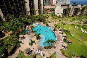Ein Resort mit einem zentral gelegenen Pool, Liegebereichen und üppiger Bepflanzung.