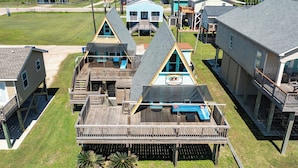 Une propriété située en bord de mer, comprenant plusieurs constructions en bois, notamment une maison principale et plusieurs petits chalets, reliés par une terrasse en bois.