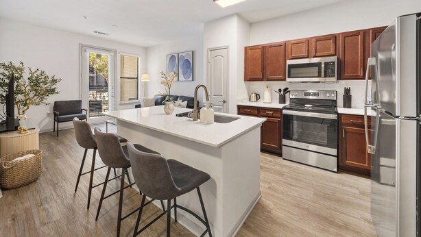 A modern kitchen with a central island, stainless steel appliances, and wooden cabinets. - Modern Styled  1 King+Sofa Bed Retreat Frisco, TX (Frisco)