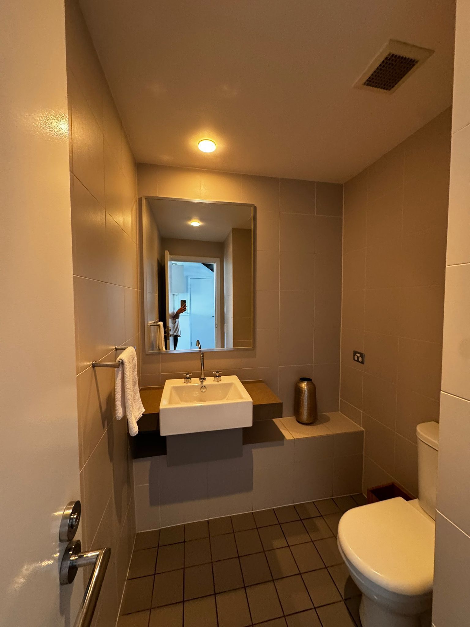 Ein Badezimmer mit Waschbecken, Spiegel, Toilette und Handtuchhalter.