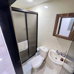 A bathroom with a toilet, bidet, sink, and a mirror. - Modern apartment in Manizales | Excellent location + Wifi + High comfort (Manizales)