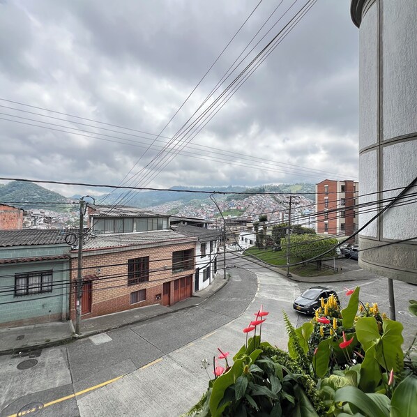 A residential street with buildings, power lines, and a distant view of a town. - Modern apartment in Manizales | Excellent location + Wifi + High comfort (Manizales)