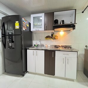 A modern kitchen with a built-in refrigerator, a gas stove, and white cabinetry.