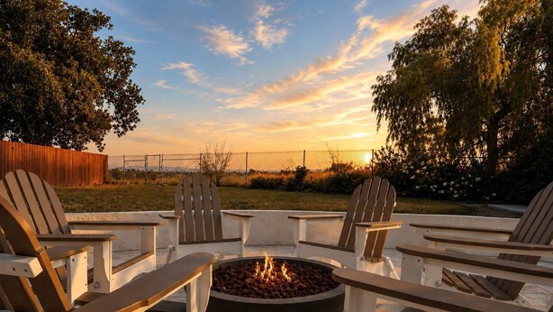 A fire pit with seating around it, a wooden fence, and trees in the background. - Hot Tub & Canyon Views! | 10 Min to La Jolla Beach (San Diego)