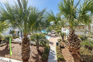 Un complexe hôtelier doté de palmiers, d’une piscine et d’un sentier menant à un bâtiment.