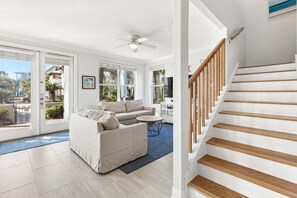 A modern living room with a sofa, a coffee table, and a staircase. - New Seacrest Beach Community! 3 BR, steps to pool, bikes and pool (Panama City)