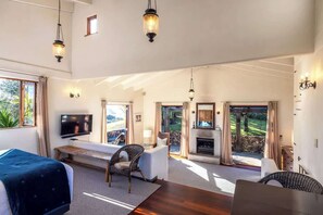 Un salón amplio con televisión, zona de estar y chimenea.