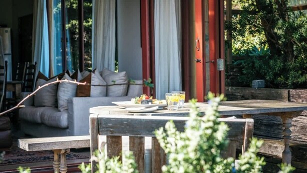 Un área de estar al aire libre con una mesa, sillas y un sofá.