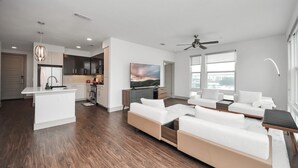 A modern apartment with a kitchen, living area, and a balcony. - Prime Houston 2BR/2BA Galleria + RiverOaks Location (Houston)