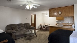 A compact living space with a sofa, a dining table, a kitchenette, and a ceiling fan. - Contractor / Plant Workers Specialty (Sulphur)