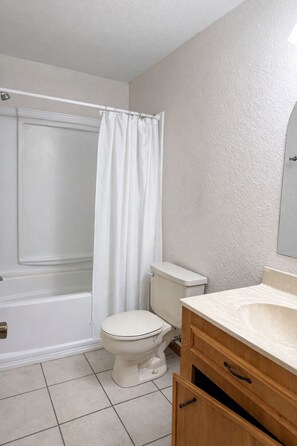 A bathroom with a toilet, a bathtub, and a sink. - Contractor / Plant Workers Specialty (Sulphur)