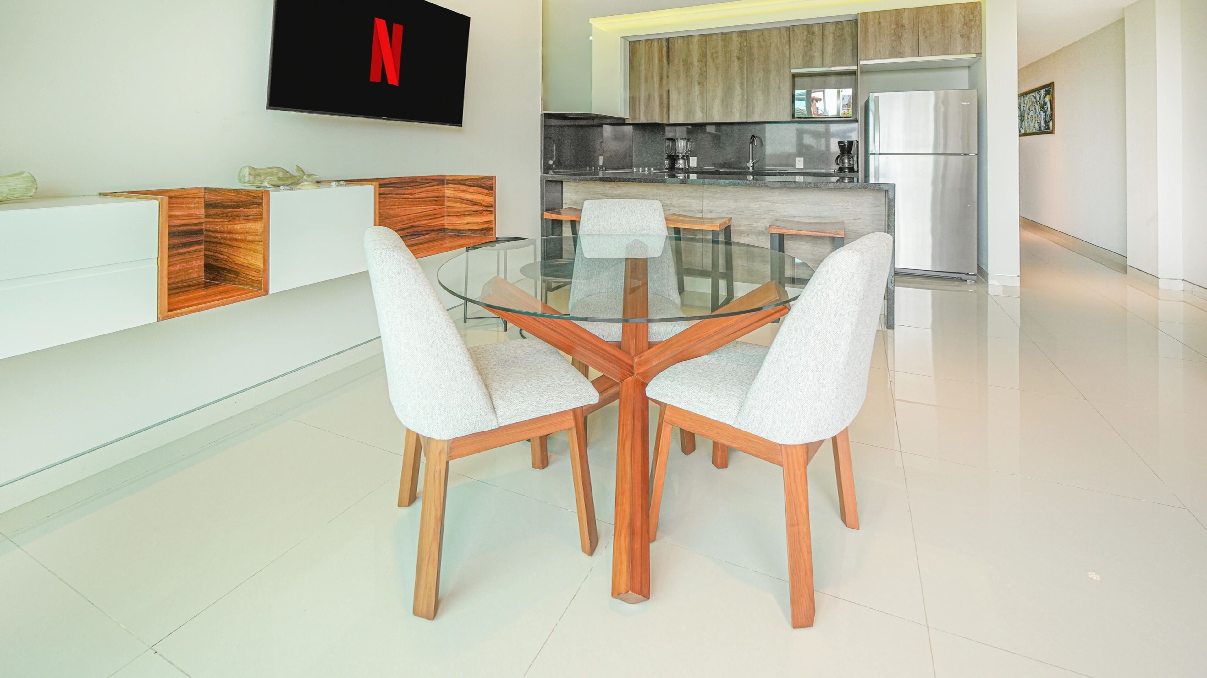 A modern kitchen with a built-in oven, a refrigerator, and a coffee maker.