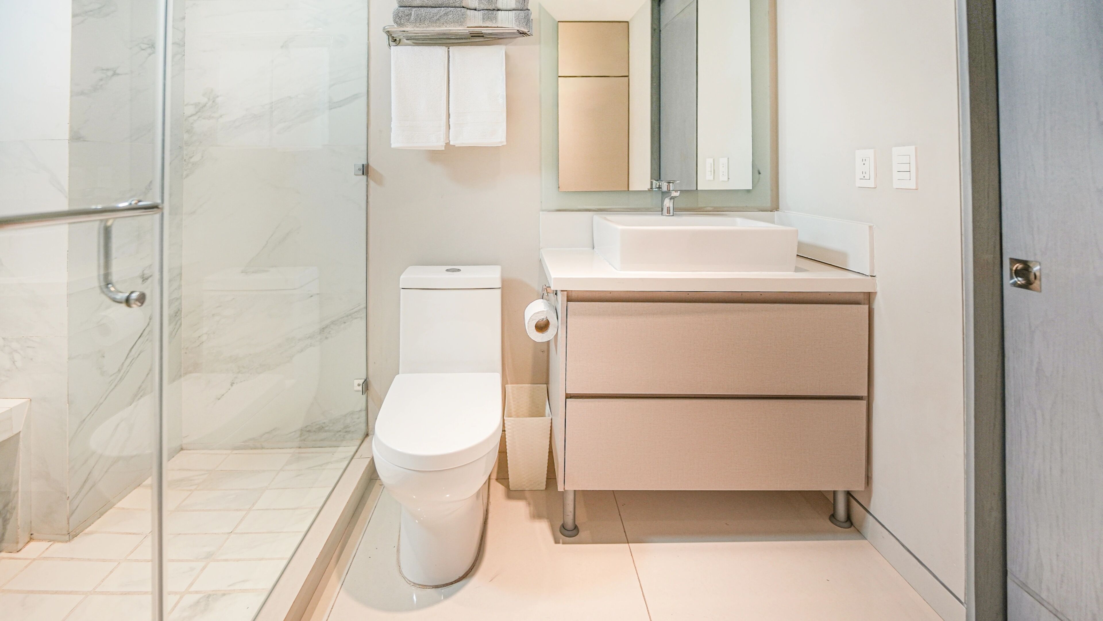Une salle de bain moderne équipée de toilettes, d’une douche et d’un lavabo.