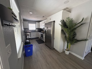 A modern kitchen with white cabinets, stainless steel appliances, and a potted plant. - Move-In Ready 3BR Near MacDill AFB. All Utilities Included + Fast WiFi (Tampa)