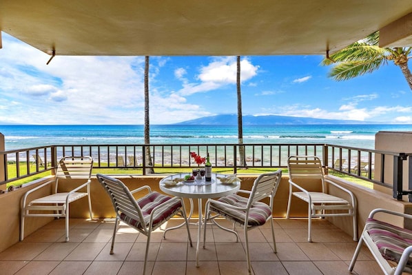 A balcony with a table, chairs, and a view of the ocean. - New Listing! Oceanfront 2BR Maui Escape (Honokowai)