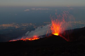 Ein Vulkanausbruch, bei dem Lava eine Bergflanke hinabfließt.