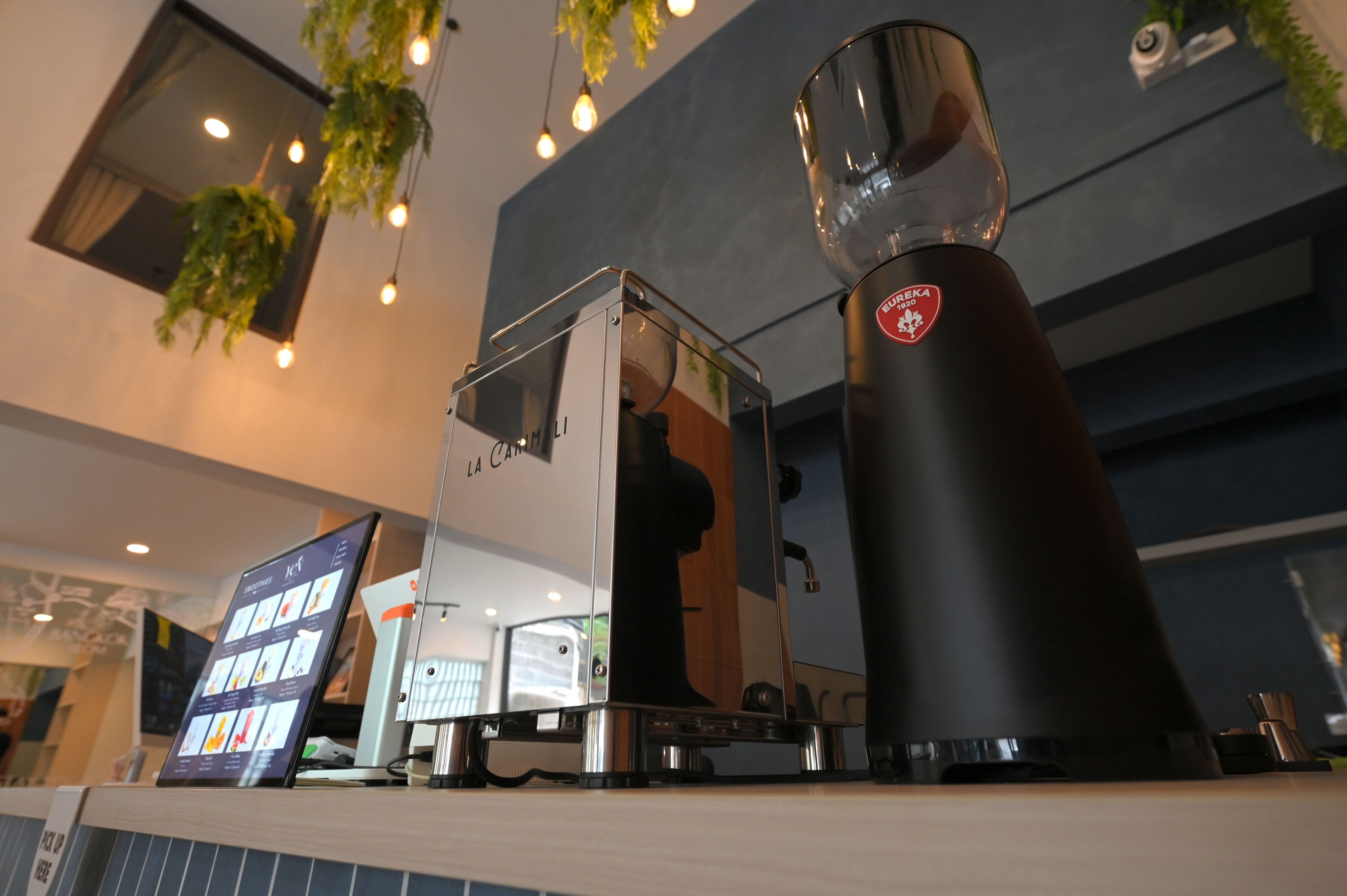A coffee machine with a glass carafe and a digital menu display.