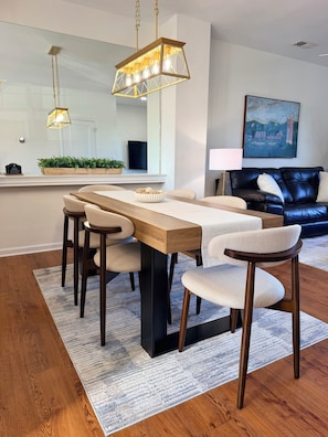 A modern dining area with a wooden table, matching chairs, and pendant lighting. - Overlook at Liberty: Sleeps 10, <1 Mile to LU + Campus & Mountain Views (Lynchburg)