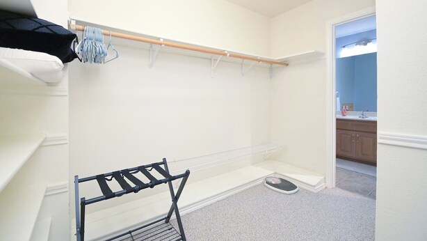 A walk-in closet with a hanging rod, a shoe rack, and a small scale. - Views! Near Lake - Hot tub - King Mstr w/ Balcony (Canyon Lake)