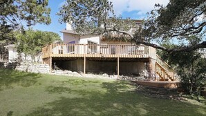 A two-story house with a wooden deck and a stone foundation. - Views! Near Lake - Hot tub - King Mstr w/ Balcony (Canyon Lake)
