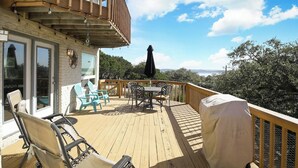 A wooden deck with outdoor furniture, a covered grill, and a view of the landscape. - Views! Near Lake - Hot tub - King Mstr w/ Balcony (Canyon Lake)