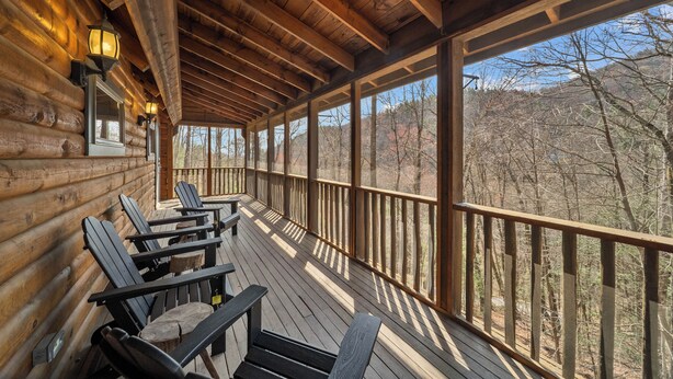 A wooden deck with Adirondack chairs and a view of trees. - Family-Friendly Blowing Rock Retreat | Fire Pit, Game Room, & Cozy Mountain Views (Lenoir)