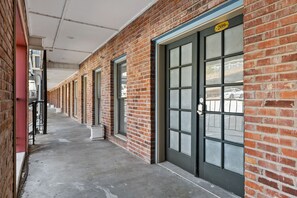A row of brick buildings with large windows and a concrete floor. - Hearth & Harvest | Historic St. Charles 2BR (Saint Charles)