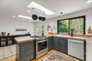 Een moderne keuken met een groot raam, een inbouwoven en een vaatwasser.