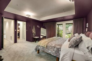 Een slaapkamer met een groot bed, een inloopkast en uitzicht op het landschap.