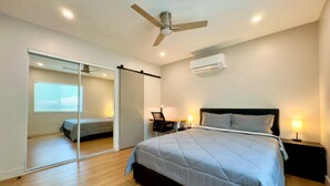A bedroom with a bed, a ceiling fan, an air conditioning unit, a desk with a chair, and a sliding glass door leading to another room. - 3-Bed, 4-Bath Modern Home - Open Concept, Fully Remodeled & Brand-New Furnished (Los Angeles)