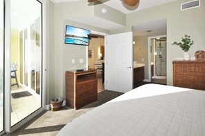 A bedroom with a bed, a dresser, a television, and a sliding glass door leading to a balcony. - NEW  Waters Edge 310 • Beautiful Beach Condo, Premium Views, Covered Pkg, Free Beach Service (Fort Walton Beach)