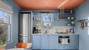 Una cucina con pensili blu, un frigorifero in acciaio inossidabile e una finestra vista.