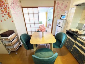 A dining area with a wooden table, two teal chairs, a vase with pink flowers, and a sliding shoji screen door. - 1 minute walk from the station | Many supermarkets and restaurants | Atmospheric downtown area | Easy access to Shibuya/Kamata, etc. (Yaguchi Ota-ku)