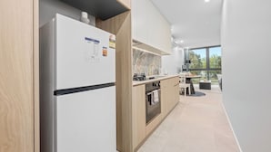 Een moderne keuken met een inbouwkoelkast, oven en spoelbak.