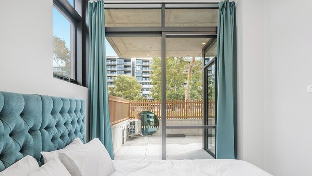 Een hotelkamer met een bed, een uitzicht op het balkon en een groot raam.