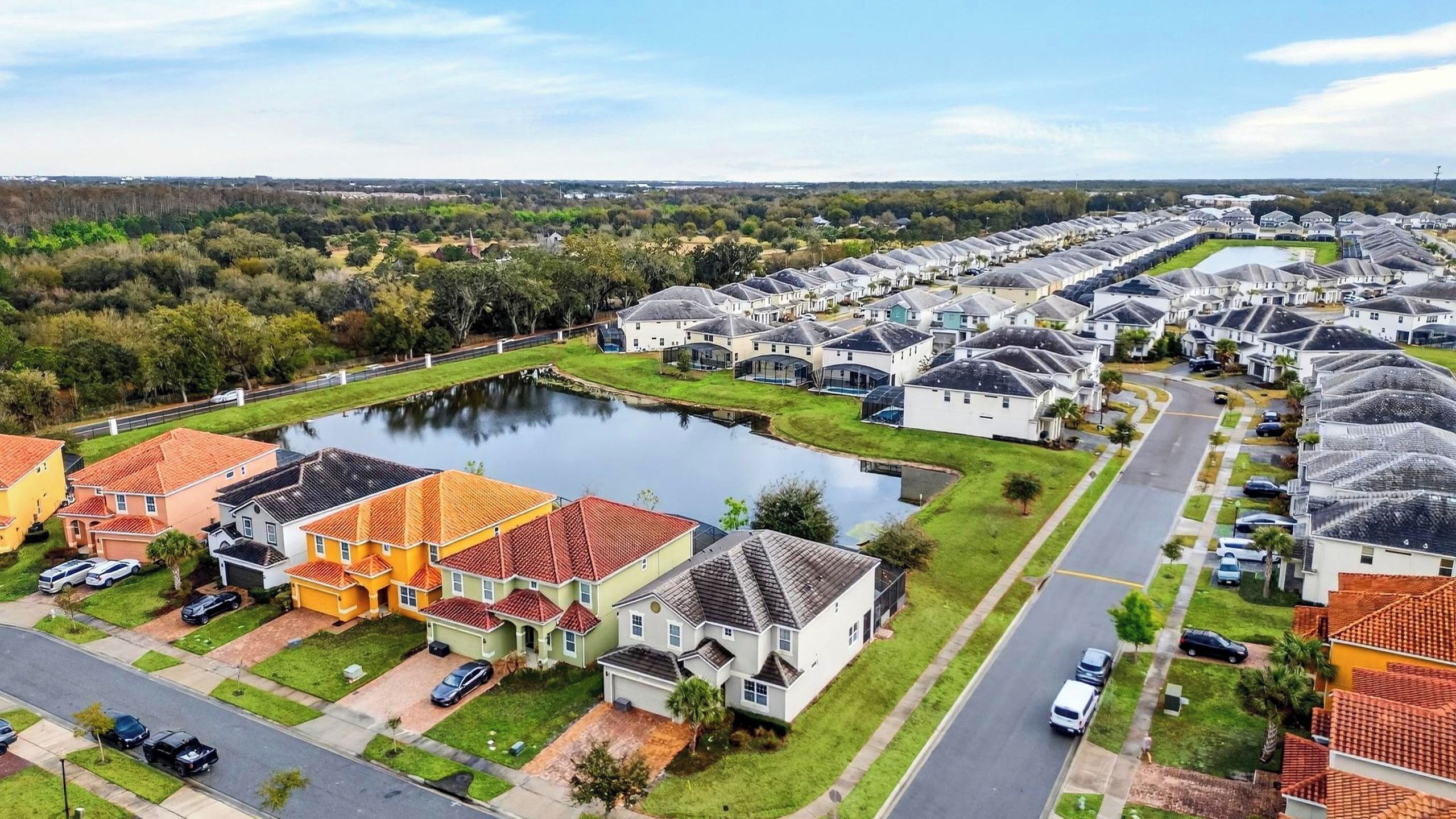 A residential area with houses, a pond, and a road.
