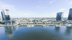 A marina with boats, modern buildings, and a clear sky. - KozyGuru | Docklands | Waterfront Skyline Retreat (Docklands)