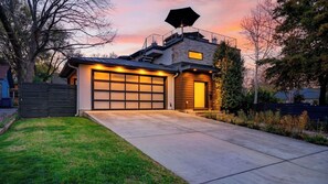 A modern house with a garage, a covered porch, and a large window.