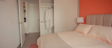 A hotel room with a bed, a wardrobe, and a walk-in closet.