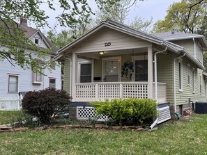 A single-story house with a front porch, a mailbox, and a number '1165' on the front. - Unique Airplane Bungalow 2BR/2BA One-of-a-Kind Stay (Topeka)