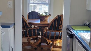 A kitchen with wooden cabinets, a dining table, and chairs.